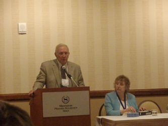Election Procedure picture of Don Stevens at the podium and Ardis Bazyn keeping track of the results